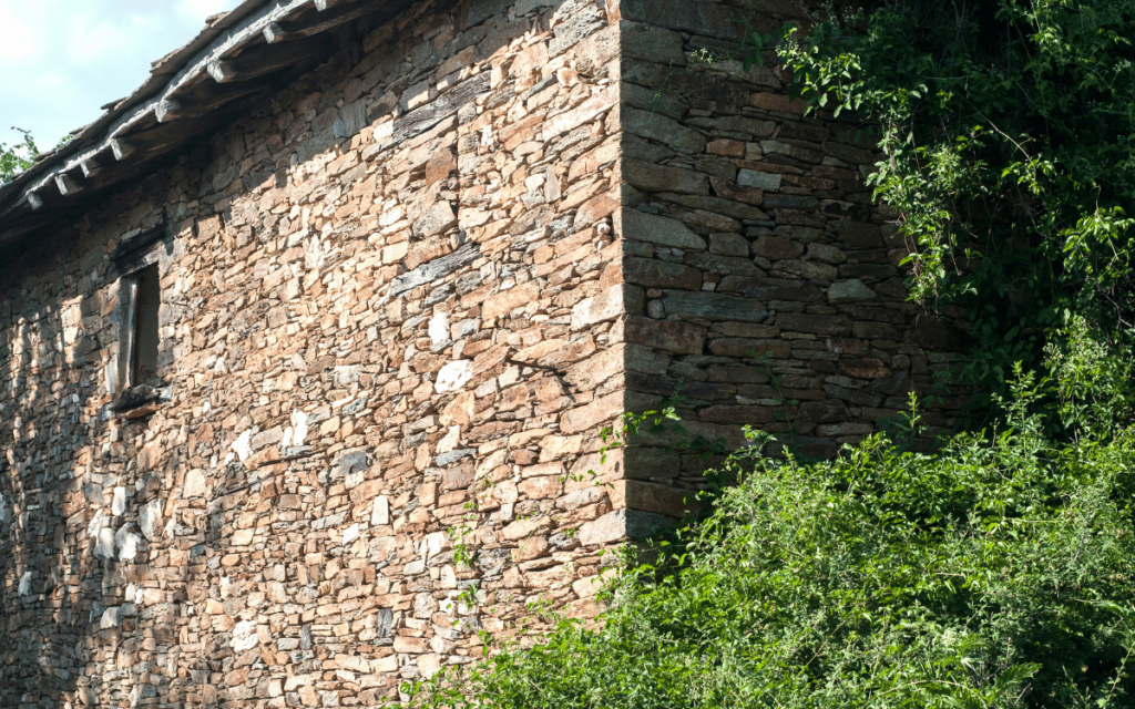 Fachada de una casa rural tradicional rodeada de naturaleza en Girona