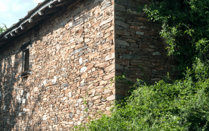 Fachada de una casa rural tradicional rodeada de naturaleza en Girona